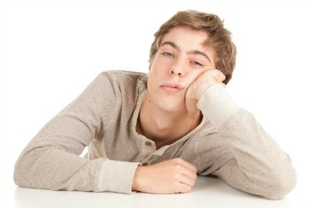 young man in grey slouse leaning on table, white background, series